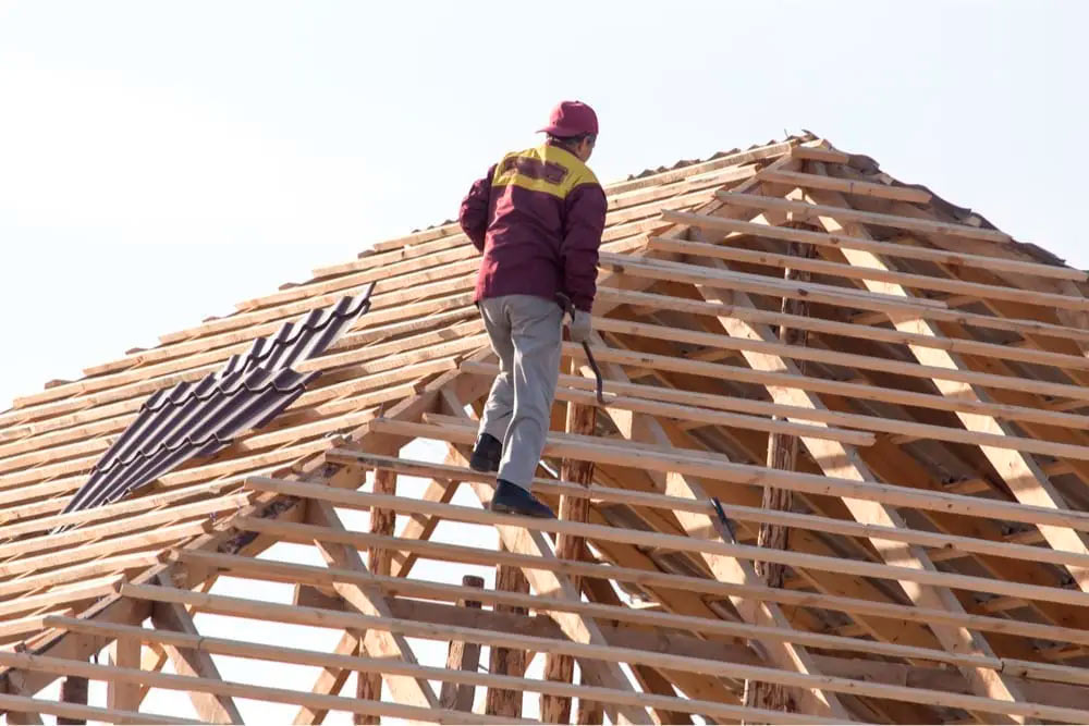 Man climbing on a roof because it knows how To Protect Your Contractor Business Against Liability Claims