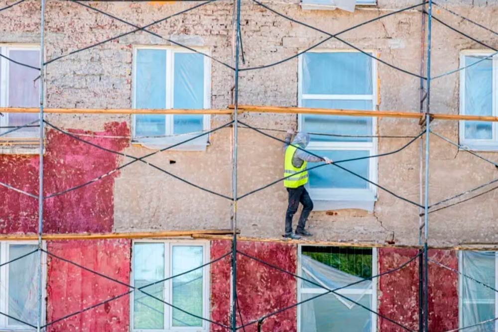 worker on scaffold who know about the Guide to Property Damage Insurance for General Contractors