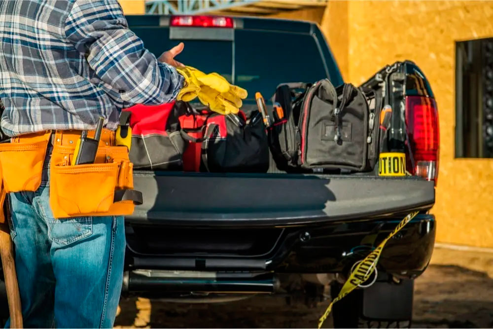 worker storing tools in a pickup truck