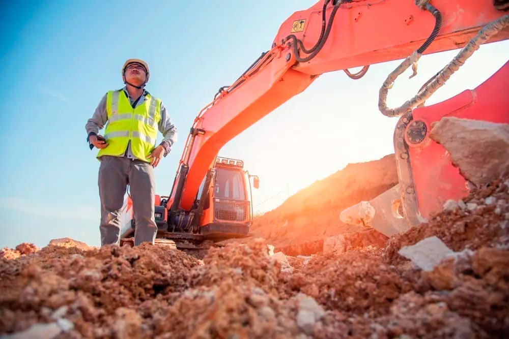 Worker beside tractor, and he knows the difference between Builder’s Risk and Inland Marine Insurance
