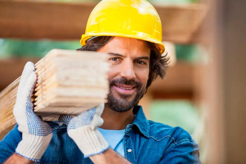 worker loading wooden beams