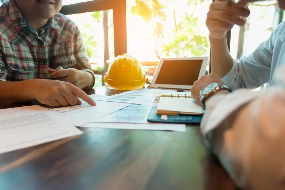 Workers in a meeting to establish contract pricing for roofing contractors or roofers