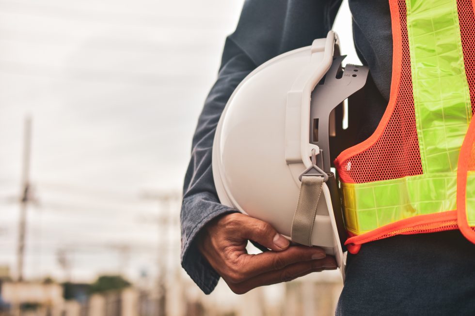 Contractor holding his hard hat with confidence because he can count on an Insurance Certificate Holder and Additional Insured and knows the difference.