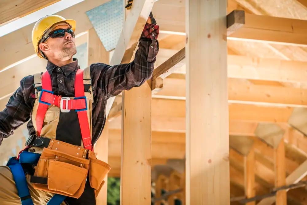 Roofer sanding a wooden beam and also he know a lot of tips on builders risk insurance