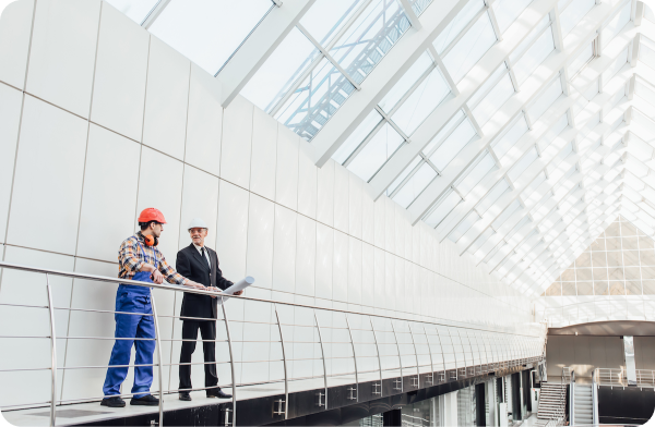 three-factory-workers-safety-hats-discussing-manufacture-plan